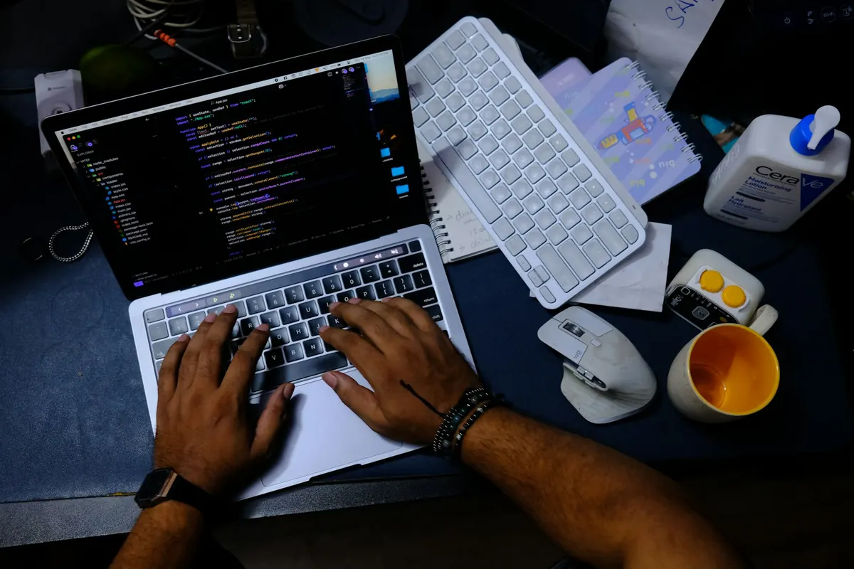 Developer typing code on a laptop to integrate push notifications into a mobile app